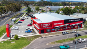 Photo of a large bright red industrial showroom and large carpark.