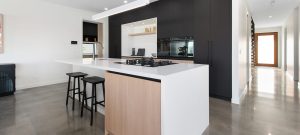 Photo of white and dark timber kitchen in display home