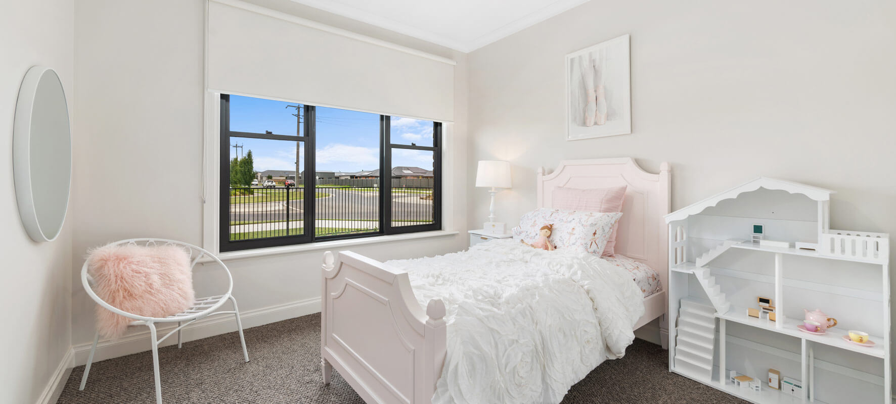 Photo of girls room in Ranch style home showing pretty pink and white bed and white dolls house