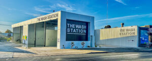 Photo of a modern new car wash business with driveway, auto car wash and bays for people to wash their own cars.