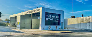 Photo of a modern car wash showing the entry, signage, and spaces to wash cars