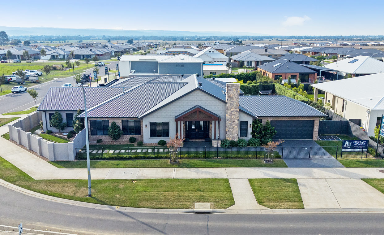 Aerial view of tin roof of large ranch style home on corner block.