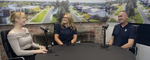 Two women and a man sitting at a table recording a podcast for Virtue Homes about the process of building a custom home.
